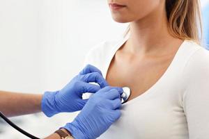 femme adulte en cours d'examen avec stéthoscope par une femme médecin photo