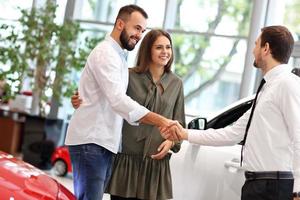 jeune couple choisissant une voiture dans la salle d'exposition photo