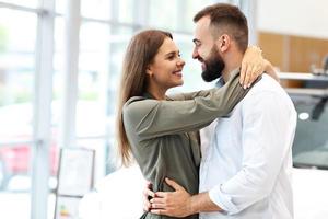 couple adulte choisissant une nouvelle voiture dans la salle d'exposition photo