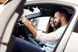 couple adulte choisissant une nouvelle voiture dans la salle d'exposition photo