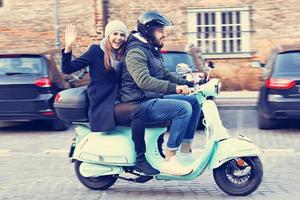 beau jeune couple souriant en faisant du scooter en ville en automne photo