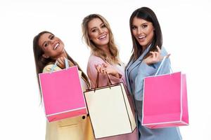 Trois femmes en costumes pastel holding shopping bags over white background photo