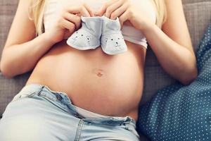 femme enceinte heureuse reposant sur un canapé photo