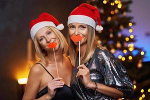 jeunes copines sympas ou couple s'amusant à la fête de noël ou du nouvel an photo