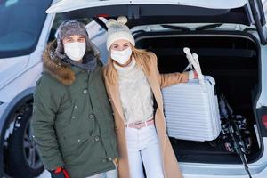 jeune famille pendant le voyage d'hiver dans le coffre de la voiture photo