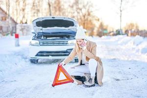 jeune femme ayant des problèmes avec la voiture en hiver photo