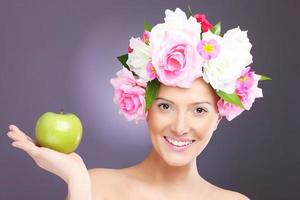 femme avec des fleurs et une pomme verte photo