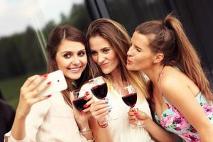 groupe d'amis avec du vin prenant selfie photo