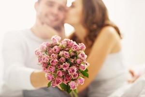 homme donnant des fleurs à une femme au lit photo