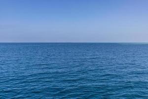 vagues de l'océan bleu horizon sans fin. surface de la mer bleue et ciel bleu clair photo