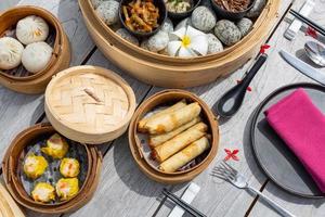 yumcha, divers dim sum dans un bateau à vapeur en bambou dans un restaurant chinois. boulettes chinoises servies sur le bateau à vapeur traditionnel décoré. image de dim sum photo