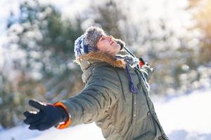 jeune bel homme s'amusant dans les bois dans un paysage d'hiver photo