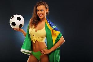 heureux fan brésilien acclamant avec drapeau et football photo