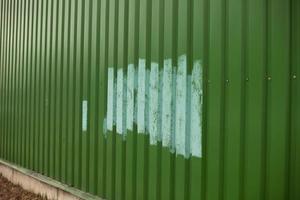 Clôture peinte après vandalisme. peindre sur des graffitis sur la clôture. photo