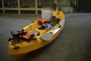 bateau jaune en plastique. canoë dans garage. équipement sportif. préparation pour la randonnée. photo