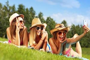 groupe de femmes en bikini prenant un selfie à l'extérieur photo