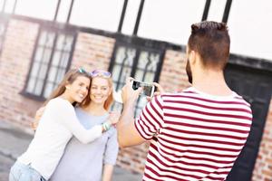 groupe d'amis heureux prenant des photos dans la ville