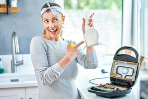femme nettoyant un gril ou un grille-pain dans la cuisine photo