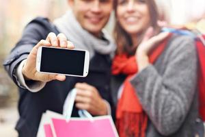 au milieu d'un couple faisant du shopping dans la ville avec un smartphone photo