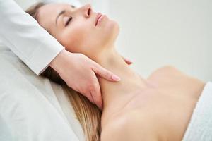 jeune femme agréable ayant un massage du visage au spa photo