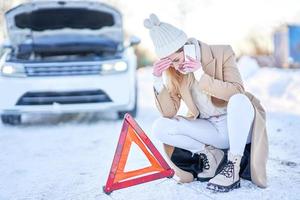 jeune femme ayant des problèmes avec la voiture en hiver photo