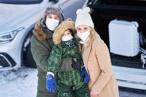 jeune famille pendant le voyage d'hiver dans le coffre de la voiture photo