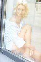 jeune jolie femme assise à la fenêtre le matin photo