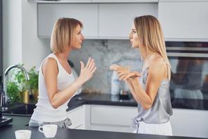 belles deux filles adultes dans la maison se disputent photo