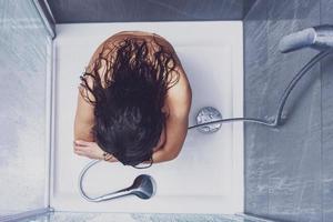 femme adulte sous la douche dans la salle de bain photo