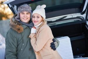 jeune famille pendant le voyage d'hiver dans le coffre de la voiture photo