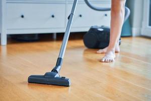 photo d'une femme qui nettoie sa maison à l'aide d'un aspirateur