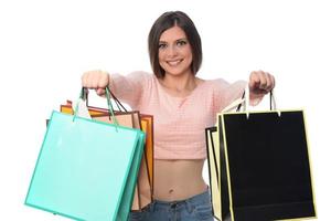 image d'une belle jeune femme brune posant avec des sacs à provisions et regardant la caméra. notion d'achat. isolée photo