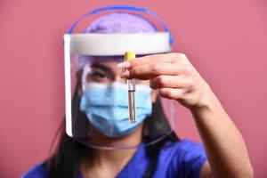 femme médecin asiatique en gros plan portant un écran facial et une combinaison d'epi pour l'épidémie de coronavirus photo