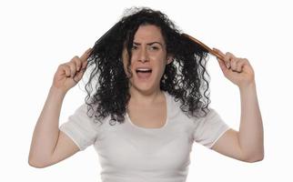 Belle femelle avec un peigne coincé dans les cheveux bouclés photo