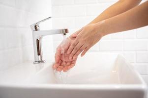 femme se lavant les mains dans la salle de bain à la maison photo