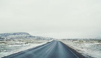 route vide à travers la photo de paysage de champ enneigé