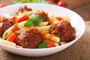 pâtes penne aux boulettes de viande à la sauce tomate dans un bol blanc photo