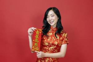 femme asiatique tenant la fortune rouge bénissant le mot chinois qui signifie être béni par une bonne étoile isolée sur fond rouge pour le concept de célébration du nouvel an chinois photo