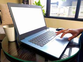 femmes utilisant un ordinateur portable travaillant à la maison avec un écran de bureau blanc vierge. photo