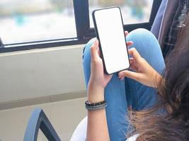 gros plan d'une main de femme tenant un écran blanc de smartphone est vierge .maquette. photo