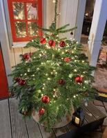 un beau petit sapin de noël décoré de boules brillantes et d'une guirlande lumineuse brillante. contenu parfait pour les bannières publicitaires, les cartes-cadeaux ou les projets créatifs. photo