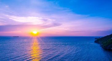 beau coucher de soleil sur la mer sur la plage tropicale avec ciel bleu et nuages pour voyager en vacances se détendre photo