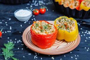 piment farci. poivron cuit avec du riz et de la viande hachée. poivrons cuits au four dans une poêle en fonte sur fond noir. nourriture roumaine saine. photo