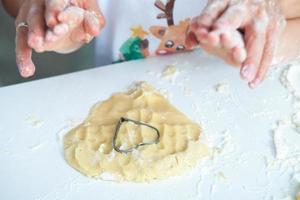 cuisine familiale des gâteaux faits maison. mamans et enfants mains tenant des emporte-pièces. cuisine familiale à plat. douce maison. notion de bonheur. photo