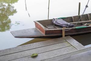 bateaux en bois des villageois amarrés avec des chaînes attachées à des poteaux. en l'absence. photo