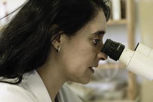 un chercheur étudiant un spécimen au microscope photo