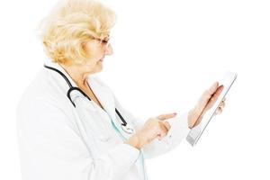 femme médecin senior à l'aide d'une tablette numérique photo