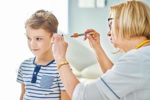 médecin pédiatre examinant les petits enfants dans la clinique vérifier les oreilles photo