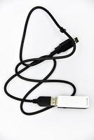 routeur sur un câble noir sur fond blanc. une clé USB blanche sur le câble. gros plan du routeur wi-fi. photo