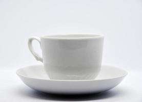 couple de thé sur fond blanc. gros plan de service en porcelaine. une tasse à thé et une soucoupe. photo